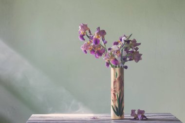 Yeşil duvara karşı güzel cam vazodaki irisler