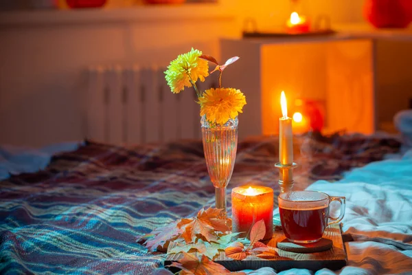 寝室でロウソクを燃やす花瓶にお茶と菊のカップ — ストック写真