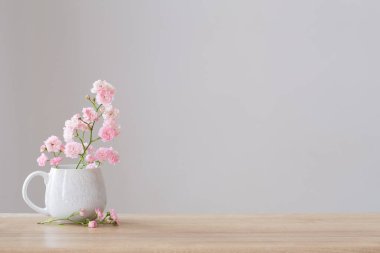 Beyaz arkaplanda seramik bardakta pembe pozlar