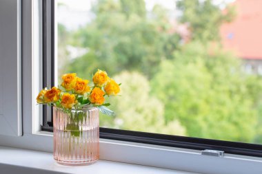 Cam vazoda sarı güller pencere kenarında
