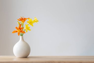 Beyaz, modern vazoda yaz çiçekleri, ahşap rafta.