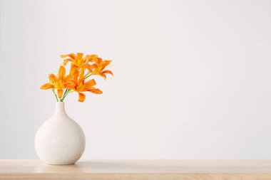 Beyaz, modern vazoda yaz çiçekleri, ahşap rafta.