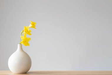 Sarı yaz çiçekleri gri arkaplanda beyaz vazoda