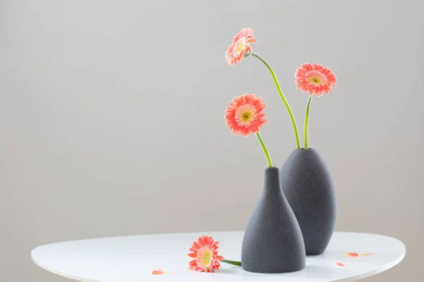 Rosa Gerber Grauen Vasen Auf Weißem Tisch Vor Grauem Hintergrund — Stockfoto