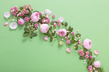Yeşil arka planda pembe çiçekler ve yeşil yapraklar