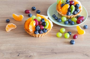 Mutfaktaki ahşap masada meyveli kekler.