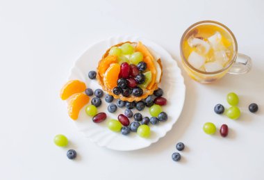 Meyveli kekler ve beyaz masada soğuk ve sağlıklı bir içecek.