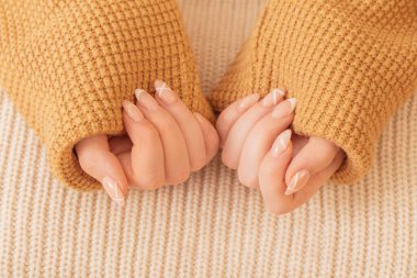 Manikürlü kadın elleri ve örgü battaniyesi