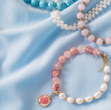 Mavi ipek kumaş üzerinde doğal taşlardan yapılmış bilezikler.