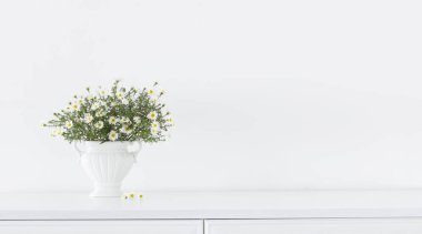 Beyaz vazodaki beyaz çiçekler beyaz iç kısımda