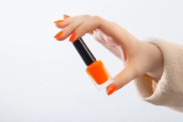 Mãos Femininas Com Manicure Laranja Com Unha Garrafa Polonês Fundo — Fotografia de Stock