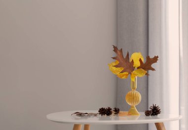 Modern iç mekanlarda cam vazoda sonbahar yaprakları