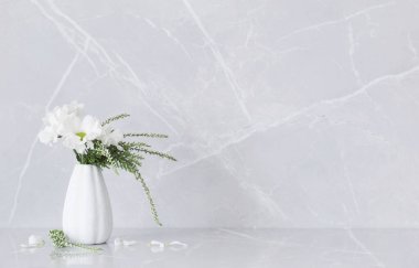 Vazodaki beyaz kasımpatılar gri mermer arka planda