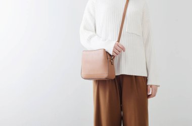 Beyaz kazaklı modern kız ve beyaz odalı kahverengi pantolon.