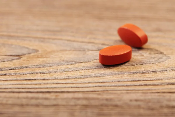two pills on old wooden background
