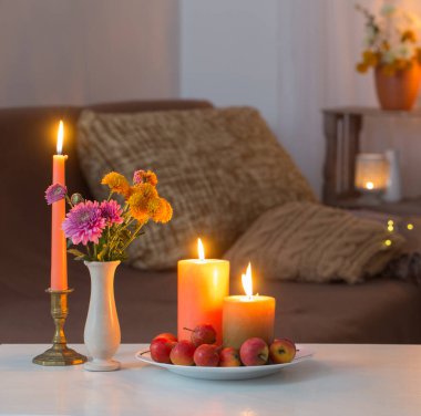 Evde yanan mumlarla sonbahar süslemeleri.