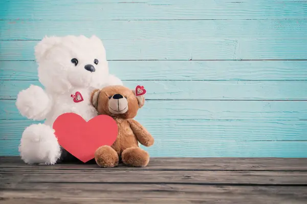 Teddy bear with red heart on old wooden background. Valentine\'s day concept