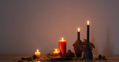 Arka plandaki ahşap rafta mumlar olan sonbahar karanlık dekoru