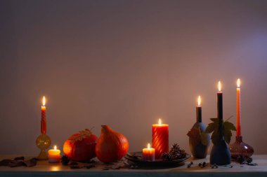 Arka plandaki ahşap rafta mumlar olan sonbahar karanlık dekoru