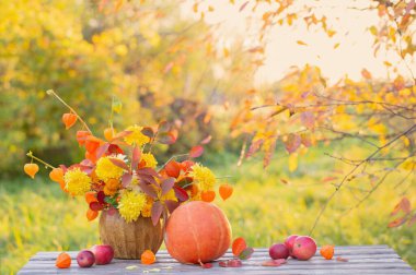Bahçedeki ahşap masada güzel bir sonbahar buketi