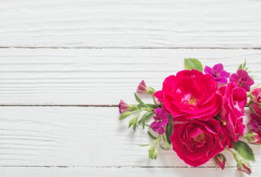 Beyaz ahşap arka planda pembe ve kırmızı güller