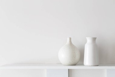 beyaz seramik vazolar ahşap rafta beyaz duvarda