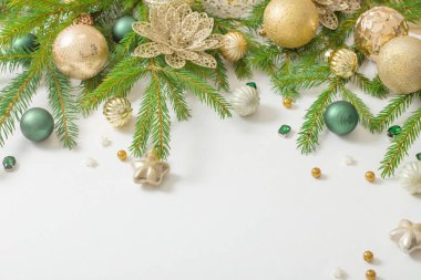 Beyaz arkaplanda altın ve yeşil noel süslemeleri