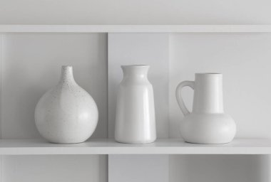 beyaz seramik vazolar ahşap rafta beyaz duvarda