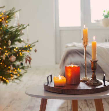 Evdeki arka plandaki Noel ağacında mum yakmak.