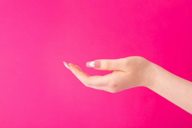 Güzel, uzun tırnaklı, manikürlü, pembe arka planda kalp deseni olan kadın elleri.