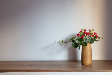 Arka plandaki gri duvarda modern vazolarda kırmızı karanfiller