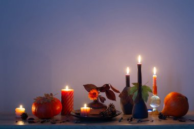 Arka plandaki ahşap rafta mumlar olan sonbahar karanlık dekoru