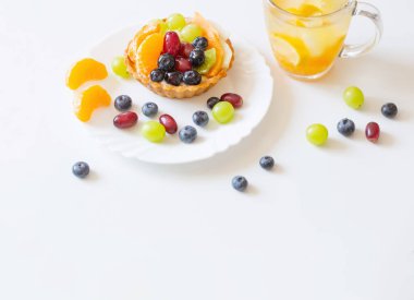 Meyveli kekler ve beyaz masada soğuk ve sağlıklı bir içecek.