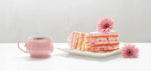 cup of tea with pink cake on white table