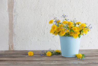 Arkadaki beyaz duvarda karahindibalar ve beni unutma notları