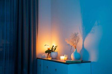 Geceleri yatak odasındaki vazoda çiçeklerle mum yakmak.