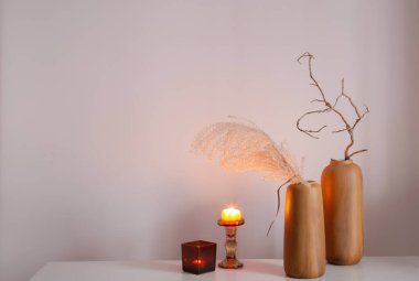 Kurumuş çiçekler ve yanan mumlarla ev dekoru.