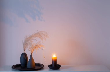 Kurumuş çiçekler ve yanan mumlarla ev dekoru.