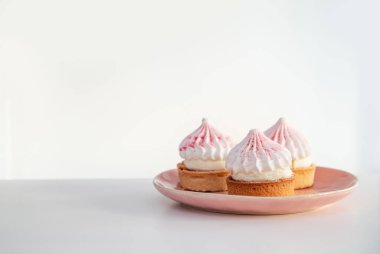 Kek pembe tabakta beyaz masada.