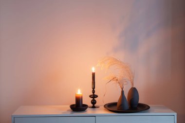 Kurumuş çiçekler ve yanan mumlarla ev dekoru.