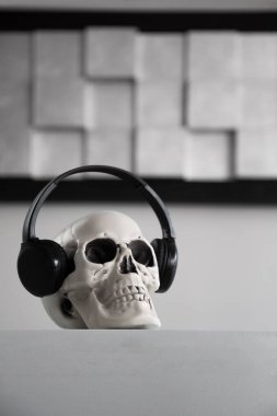 Gri arkaplandaki kulaklıklarda kafatası