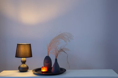 Kurumuş çiçekler ve yanan mumlarla ev dekoru.