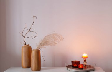 Kurumuş çiçekler ve yanan mumlarla ev dekoru.