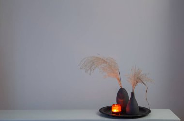 Kurumuş çiçekler ve yanan mumlarla ev dekoru.