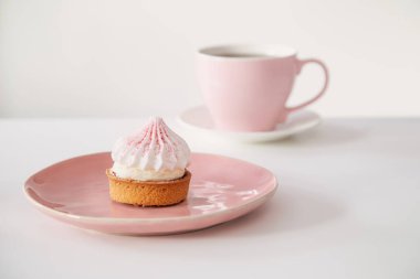 Kek, beyaz masada bir fincan kahve.