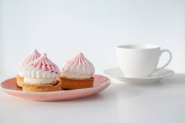 Kekler beyaz masada bir fincan kahve ile