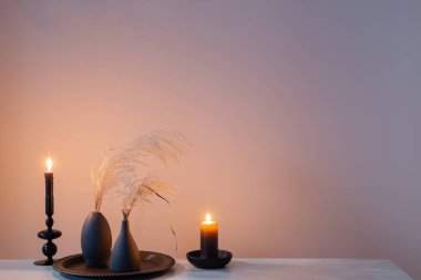 Kurumuş çiçekler ve yanan mumlarla ev dekoru.