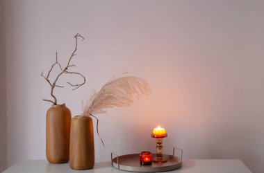 Kurumuş çiçekler ve yanan mumlarla ev dekoru.