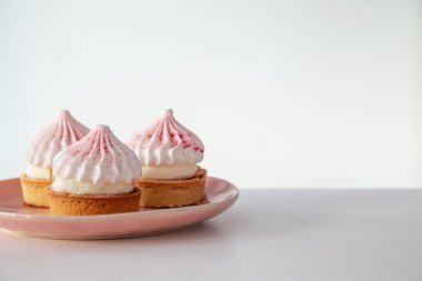 Kek pembe tabakta beyaz masada.