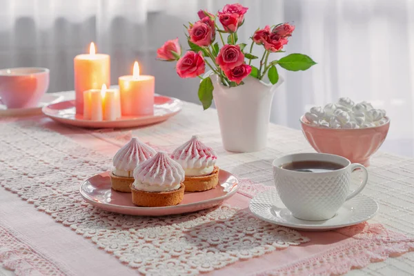 cup of coffee with dessert and roses on table